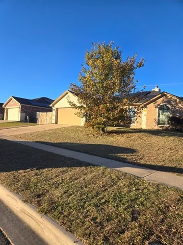 an empty room with a chandelier fan and windows