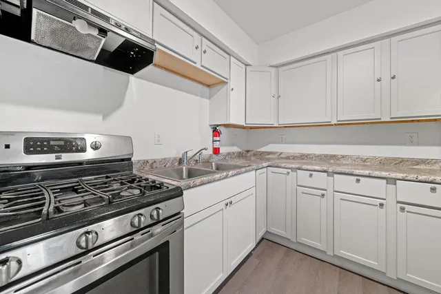 a kitchen with white cabinets and appliances