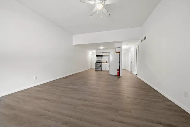 a view of empty room with wooden floor