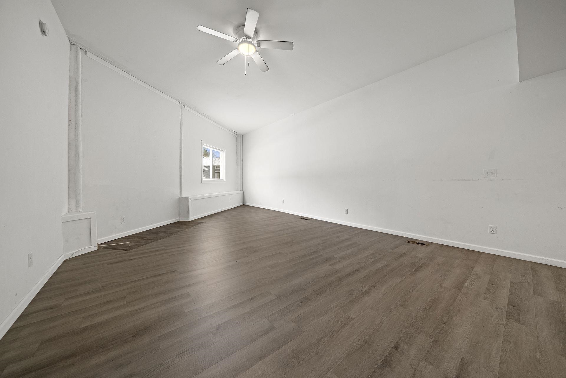 909-911 Ridge Avenue Rockford, IL 61103 - Photo 8 of 25 an empty room with wooden floor ceiling fan and window