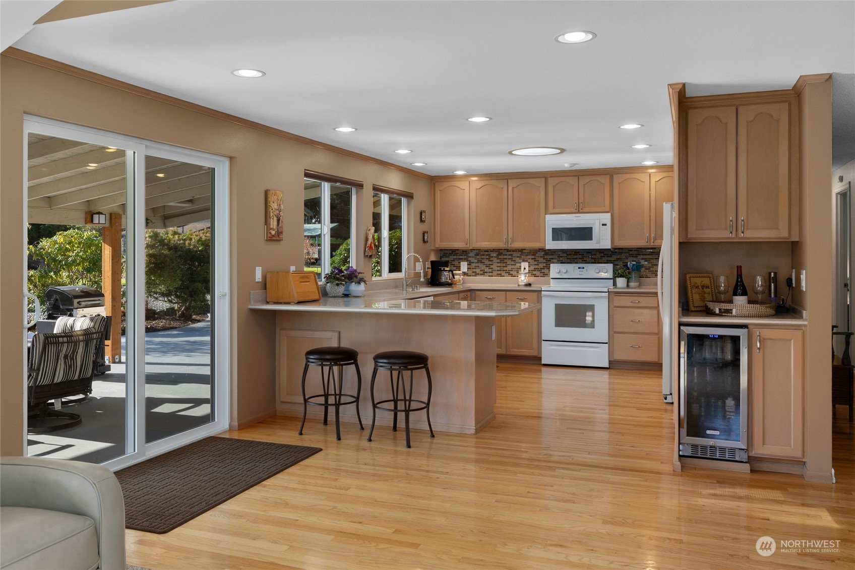 26417 Southeast 200th Street Maple Valley, WA 98038 - Photo 14 of 38 a kitchen with stainless steel appliances granite countertop a stove top oven a sink dishwasher a dining table and chairs with wooden floor
