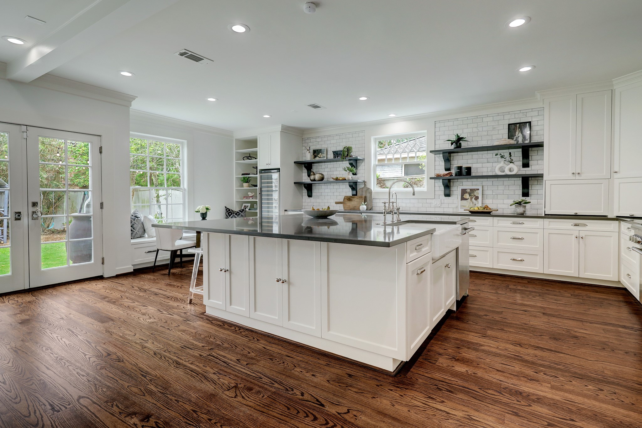 2027 Branard Street Houston, TX 77098 - Photo 14 of 36 a kitchen with stainless steel appliances kitchen island granite countertop a sink cabinets and wooden floor