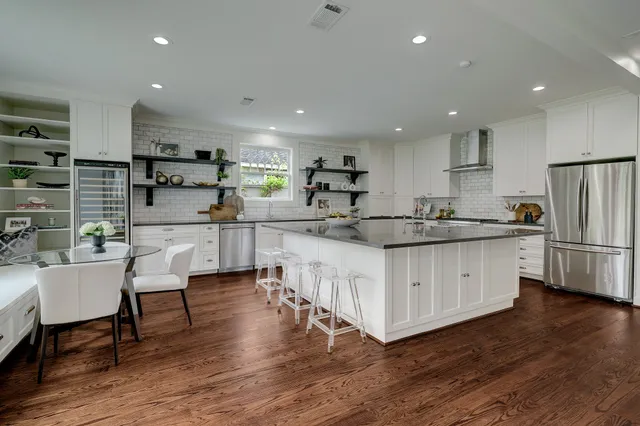 a kitchen with stainless steel appliances white cabinets a sink a stove a refrigerator and a oven