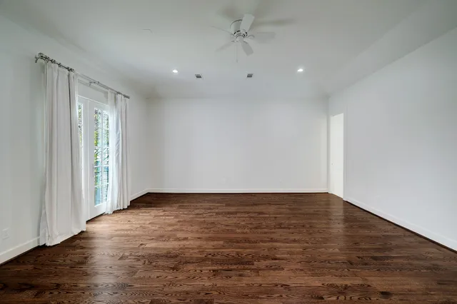 a view of empty room with wooden floor and window