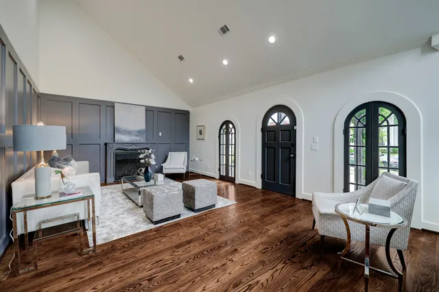 a living room with furniture a table and wooden floor
