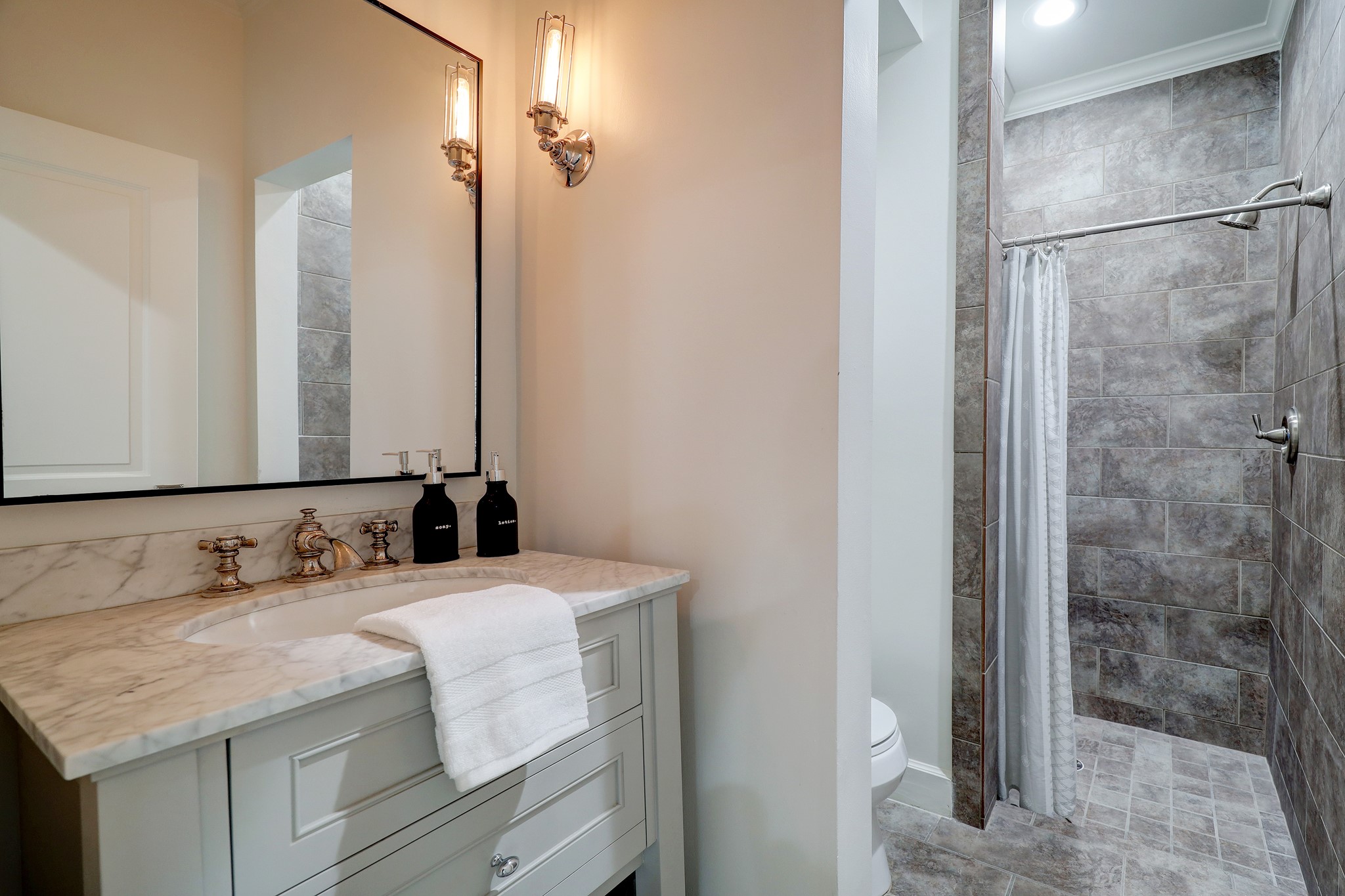 2027 Branard Street Houston, TX 77098 - Photo 10 of 36 a bathroom with a granite countertop sink and a mirror