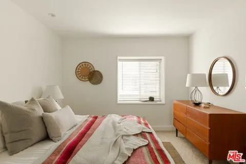 a bed room with a bed mirror and a window