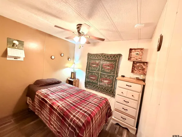 a bedroom with a bed a dresser and chair