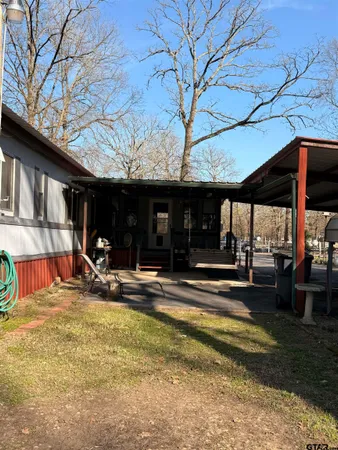 a view of a chairs and table in the patio next to a yard