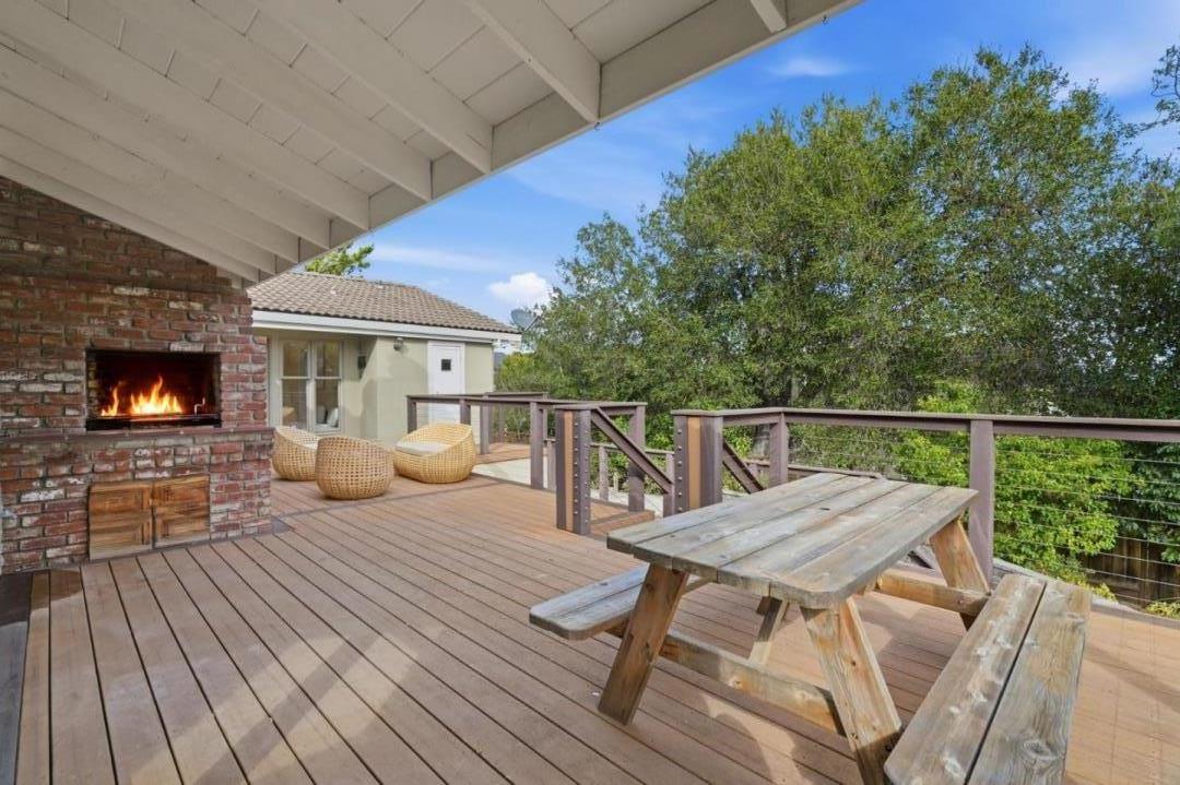 10140 Hillcrest Road Cupertino, CA 95014 - Photo 31 of 39 a view of a roof deck with table and chairs with wooden floor and fence