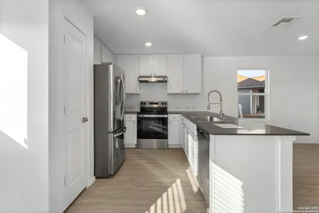 a kitchen with stainless steel appliances granite countertop a sink stove and refrigerator