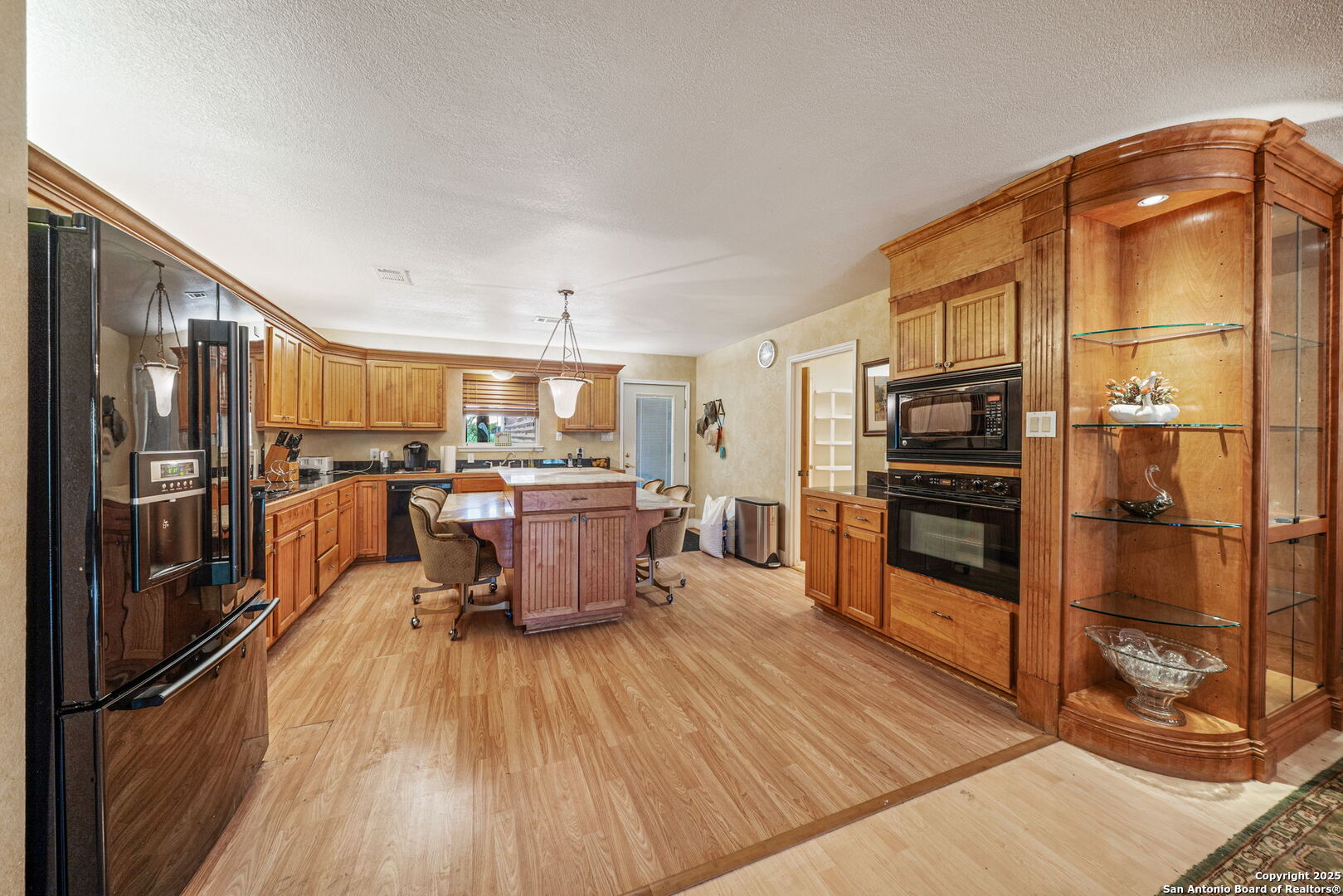1551 North Windy Knoll Drive Devine, TX 78016 - Photo 20 of 42 a kitchen with stainless steel appliances a refrigerator a stove a sink dishwasher with a dining table and chairs