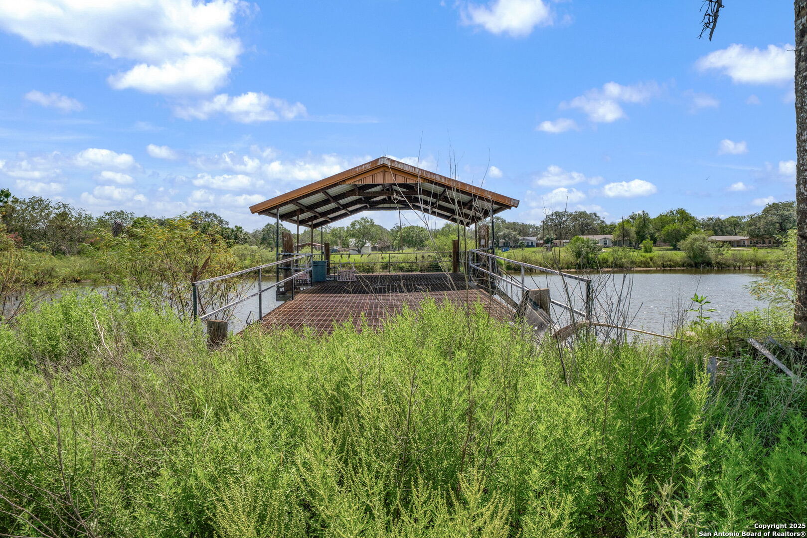 1551 North Windy Knoll Drive Devine, TX 78016 - Photo 38 of 42 a backyard of a house with lots of green space and lake view