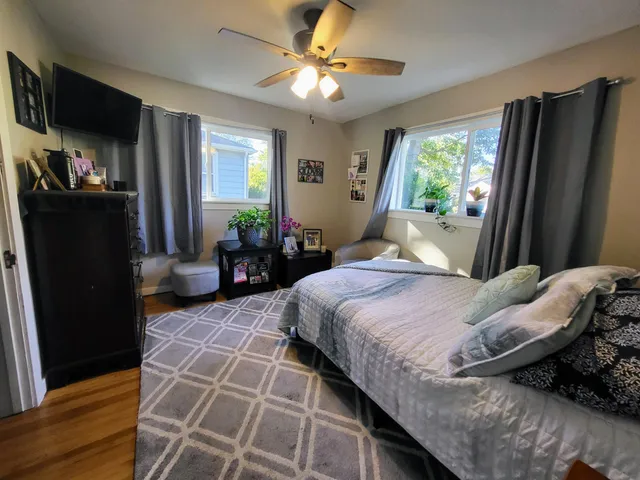a bedroom with a bed and a refrigerator