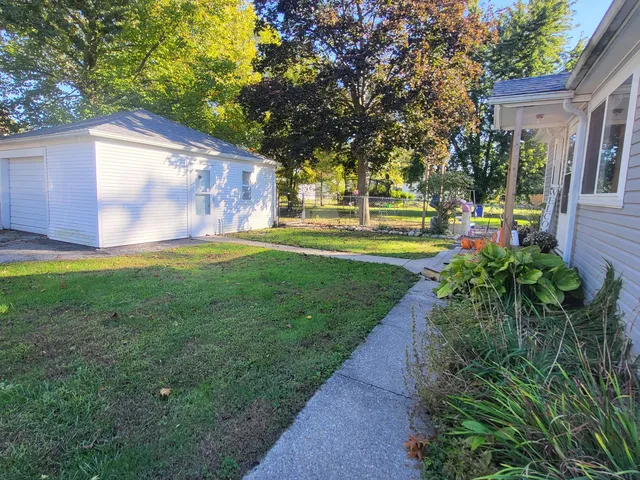 a view of a house with a big yard and potted plants