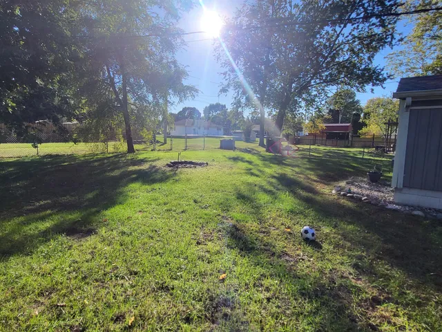 a view of a garden with a bench under an umbrella
