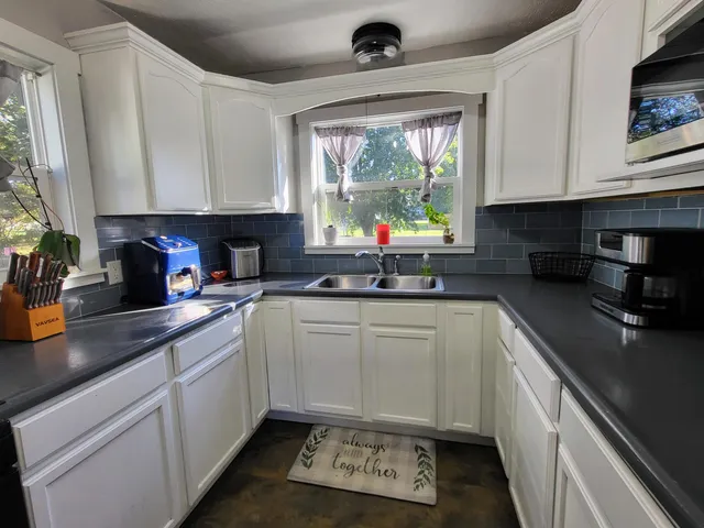 a kitchen with a sink a counter top space cabinets and appliances