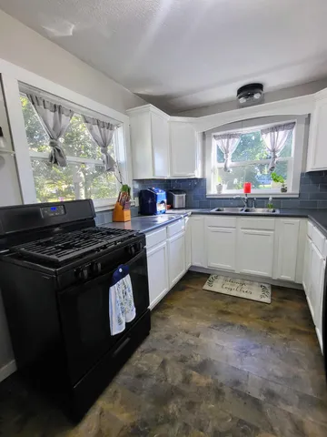 a kitchen with a stove a sink and a window