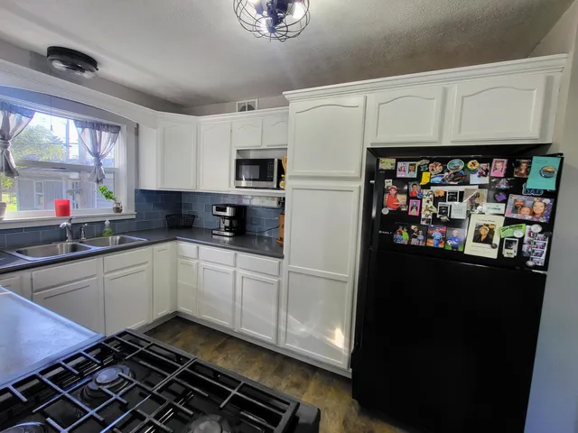 a kitchen with stainless steel appliances a refrigerator sink and microwave