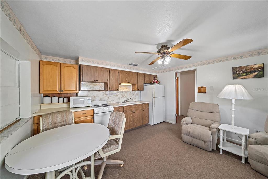 1260 Yoder Avenue Sarasota, FL 34239 - Photo 22 of 42 a large white kitchen with a stove a sink dishwasher a dining table and chairs with wooden floor