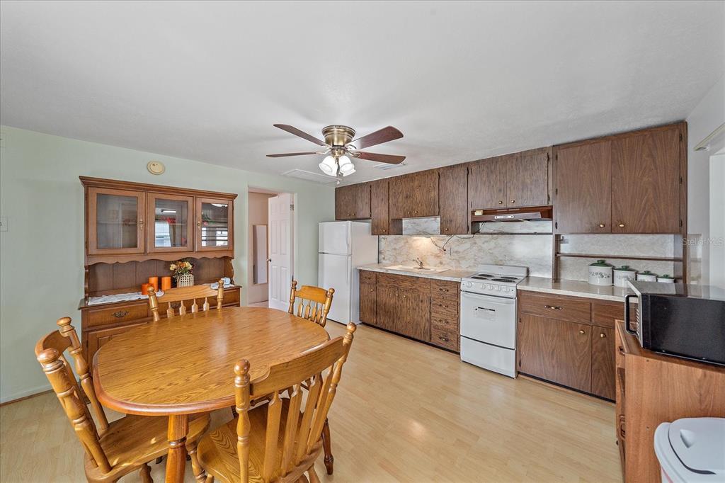 1260 Yoder Avenue Sarasota, FL 34239 - Photo 37 of 42 a kitchen with stainless steel appliances kitchen island granite countertop a table chairs and a refrigerator