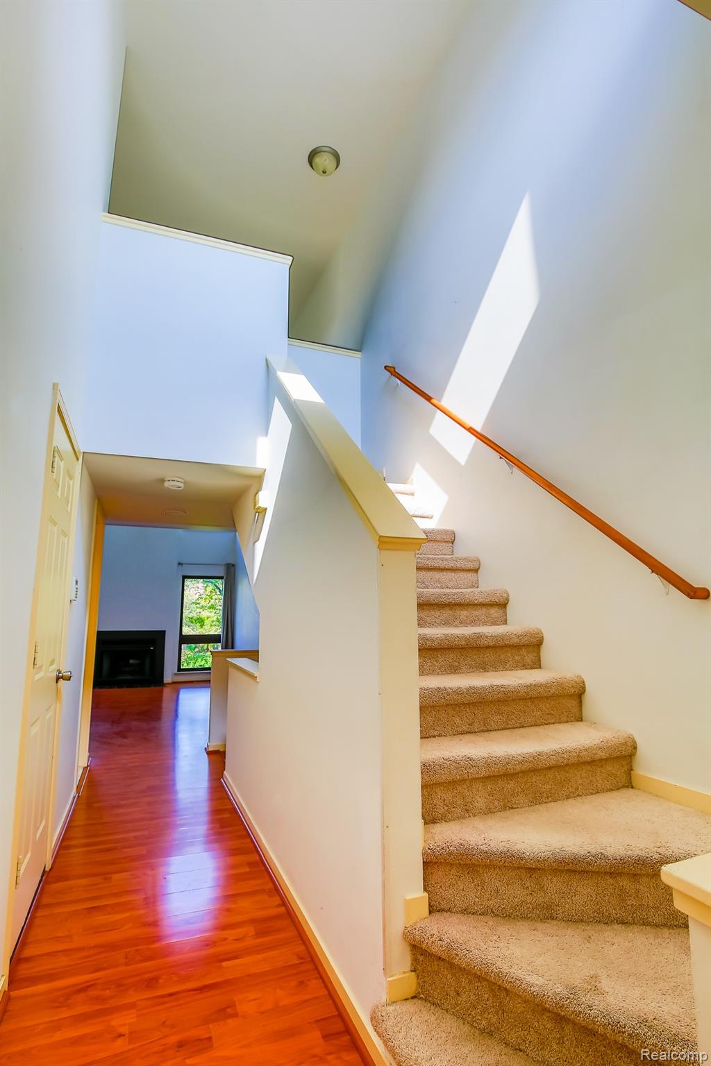 716 Eton Court Rochester, MI 48307 - Photo 10 of 41 Carpeted staircase with wooden handrail, wood-finish flooring, and recessed lighting