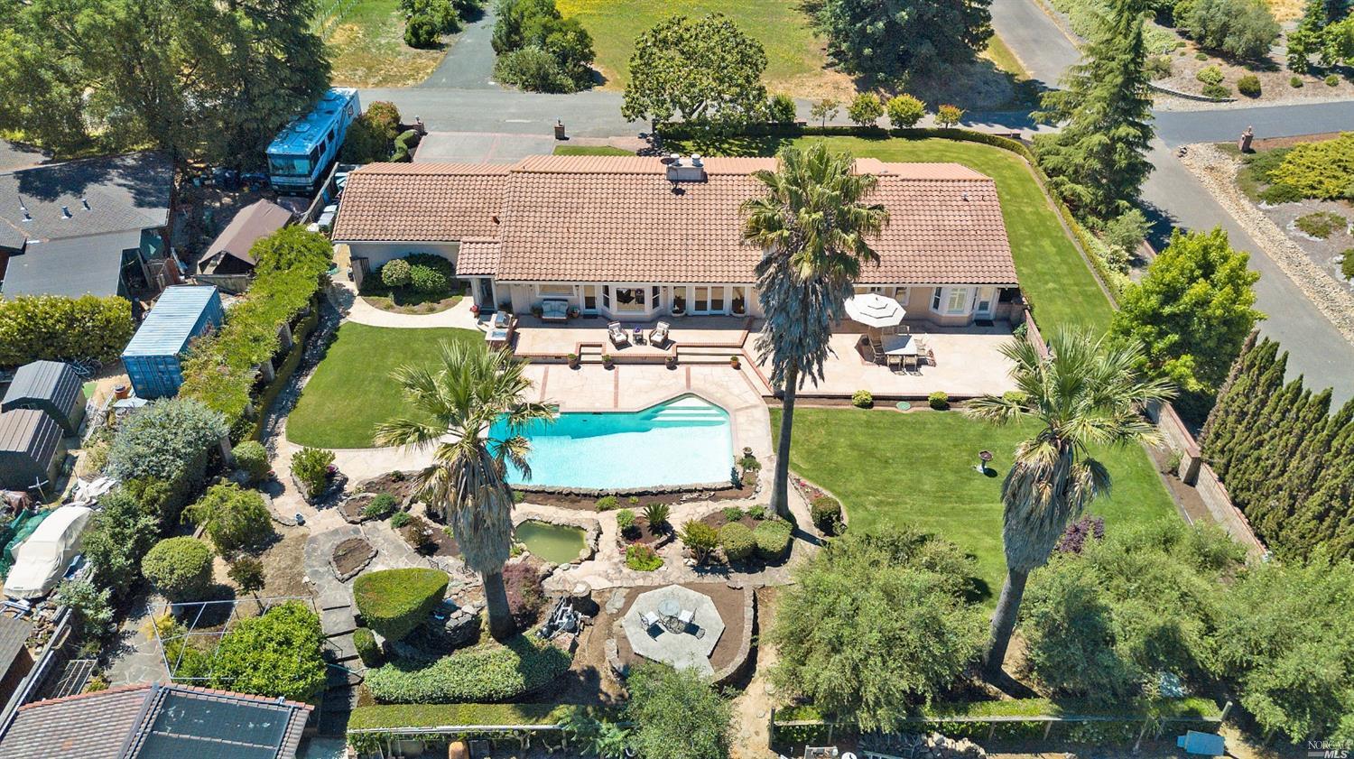 an aerial view of a house with swimming pool outdoor seating and yard
