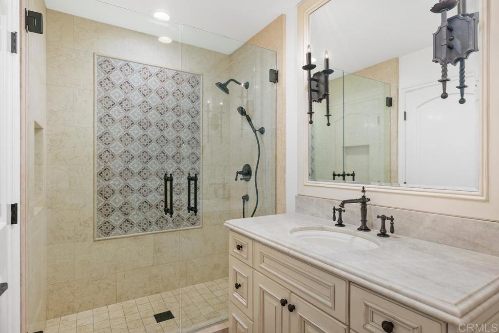 6125 La Flecha Rancho Santa Fe, CA 92067 - Photo 10 of 20 a bathroom with a granite countertop sink a mirror a vanity and a shower