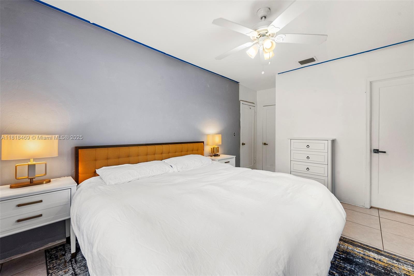 1545 Normandy Drive Miami Beach, FL 33141 - Photo 18 of 37 a large bed sitting in a bedroom and a chandelier