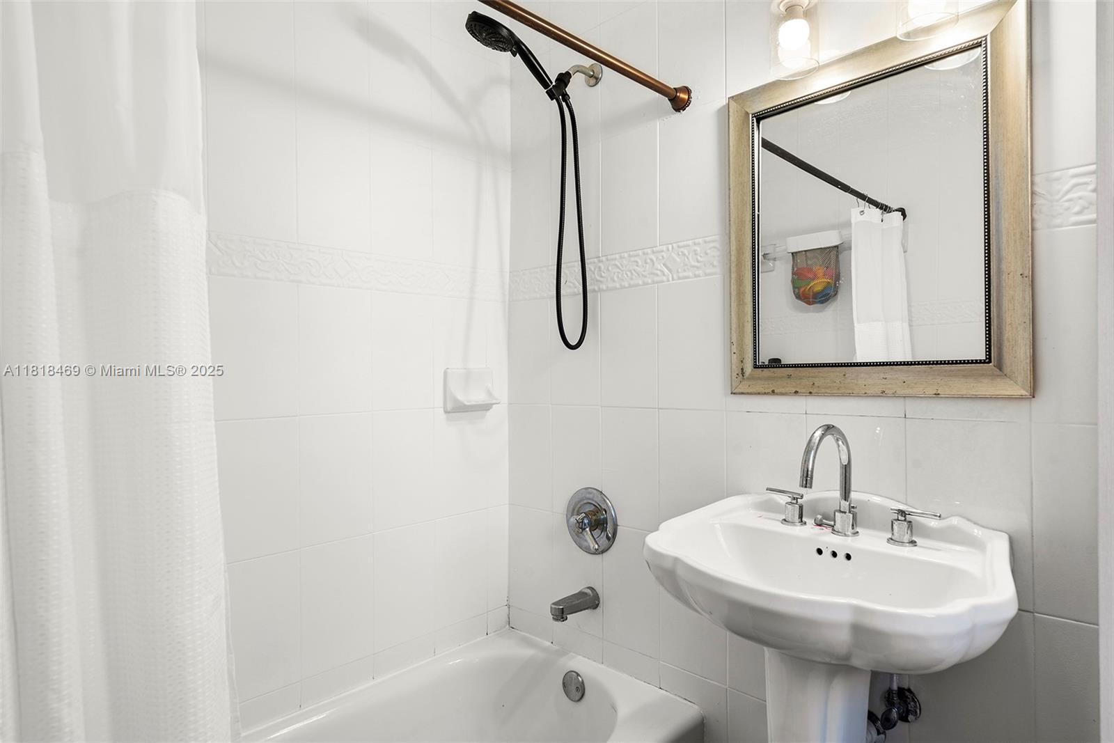 1545 Normandy Drive Miami Beach, FL 33141 - Photo 19 of 37 a bathroom with a sink a shower and a mirror