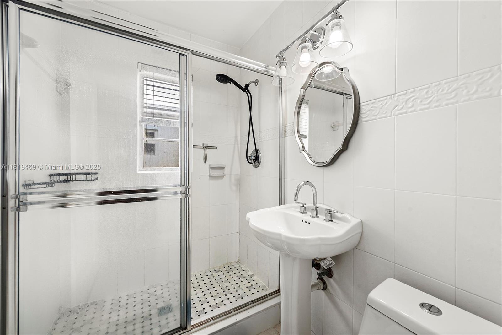 1545 Normandy Drive Miami Beach, FL 33141 - Photo 20 of 37 a bathroom with a sink toilet and a mirror