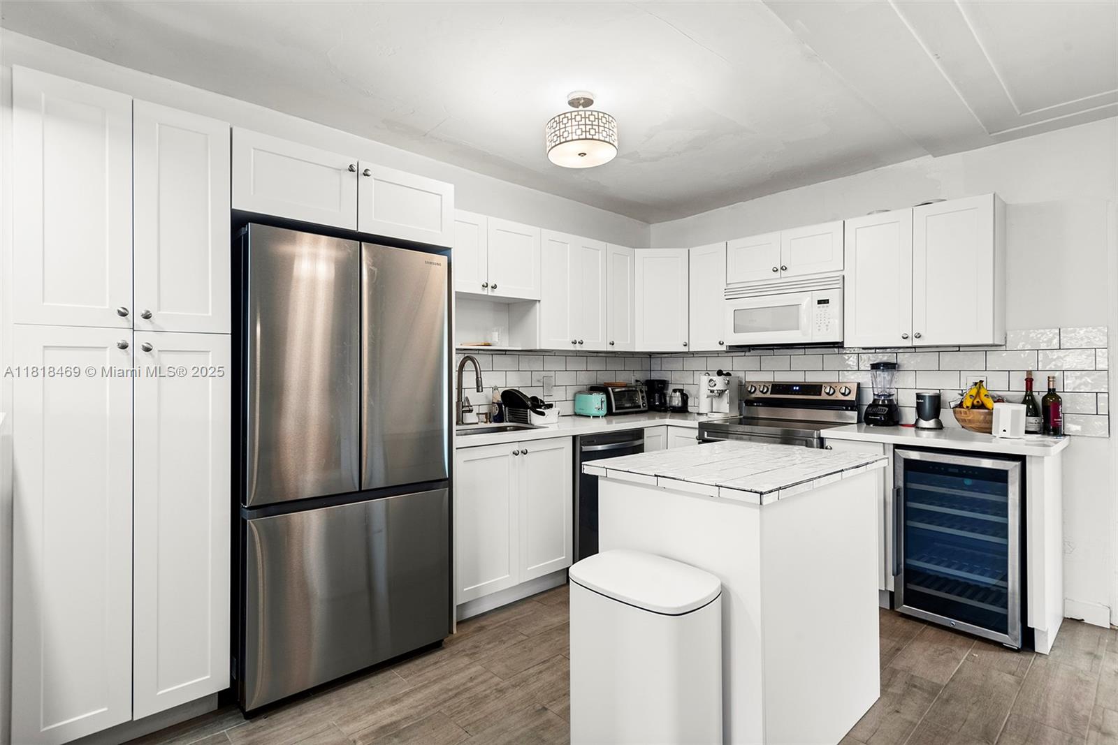 1545 Normandy Drive Miami Beach, FL 33141 - Photo 23 of 37 a kitchen with cabinets stainless steel appliances and a refrigerator