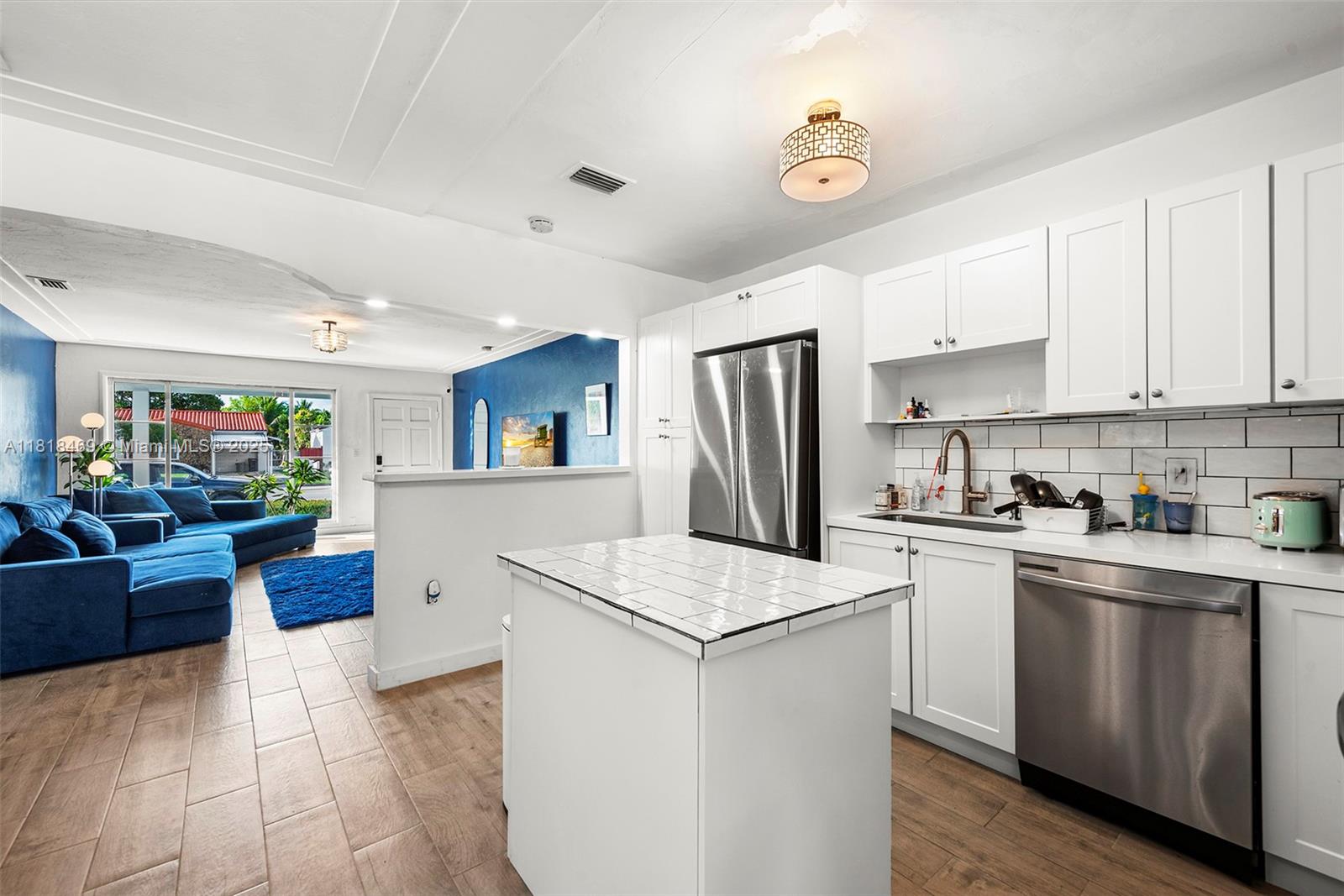 1545 Normandy Drive Miami Beach, FL 33141 - Photo 24 of 37 a kitchen with cabinets a refrigerator and a stove
