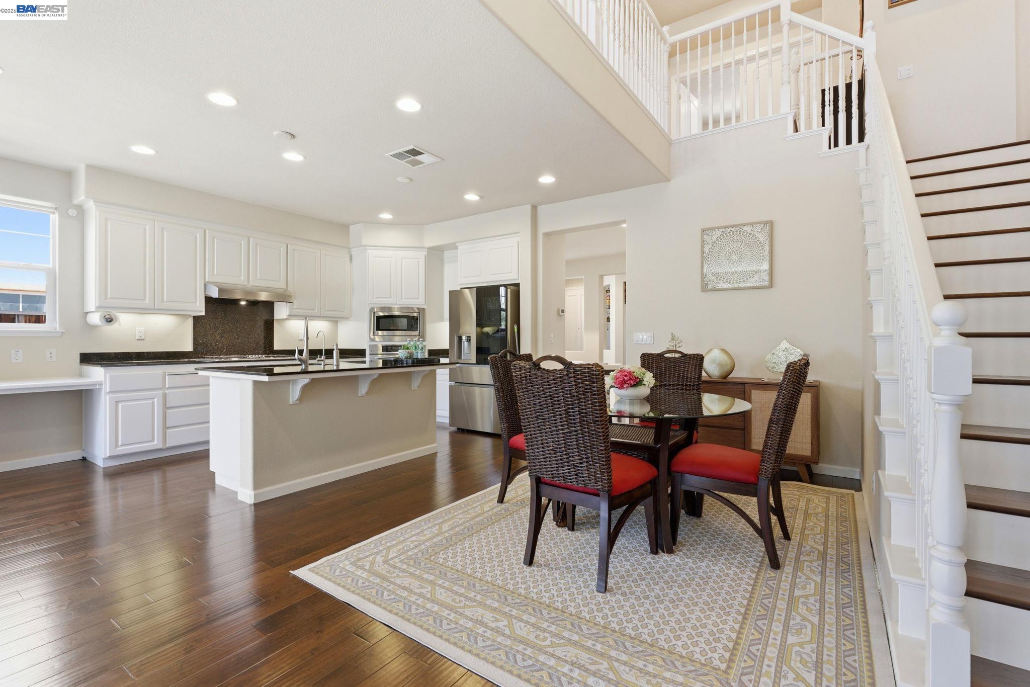 5029 Queensbury Way San Ramon, CA 94582 - Photo 12 of 58 a open dining room with stainless steel appliances kitchen island granite countertop a dining table chairs and a refrigerator