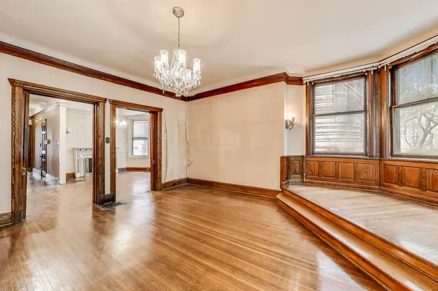 wooden floor fireplace and windows in an empty room