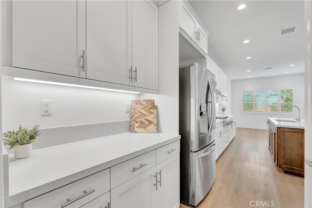 14432 Windfall Lane Huntington Beach, CA 92647 - Photo 12 of 62 a kitchen with stainless steel appliances white cabinets and a refrigerator