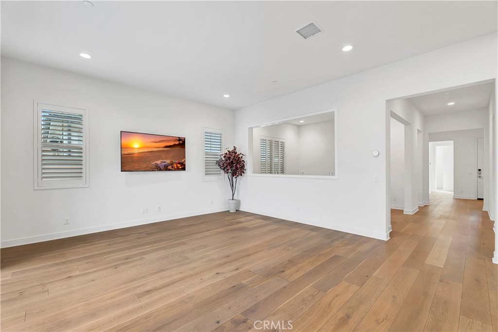 14432 Windfall Lane Huntington Beach, CA 92647 - Photo 18 of 62 a view of an empty room with wooden floor and a window