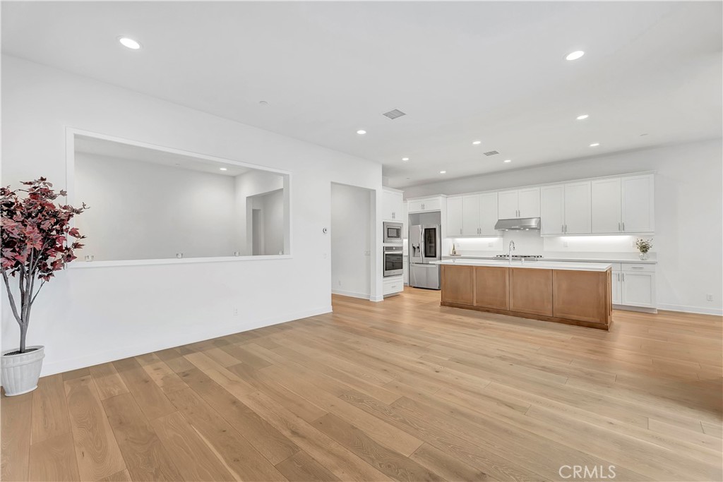 14432 Windfall Lane Huntington Beach, CA 92647 - Photo 19 of 62 a large white kitchen with kitchen island a faucet a sink and a white cabinets