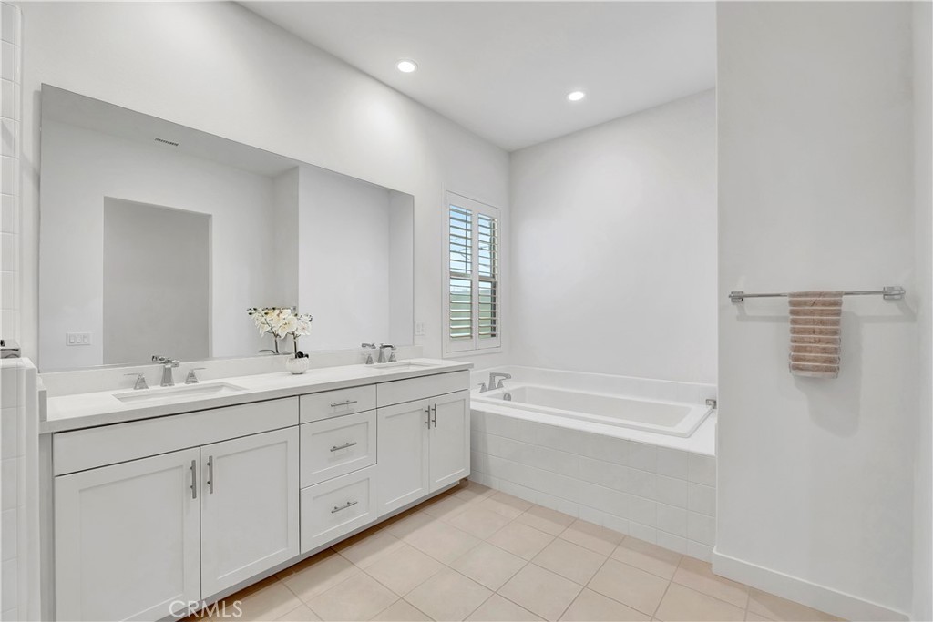 14432 Windfall Lane Huntington Beach, CA 92647 - Photo 32 of 62 a spacious bathroom with a double vanity sink a mirror and a bathtub
