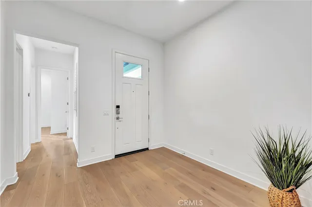 a view of a room with wooden floor and a bathroom