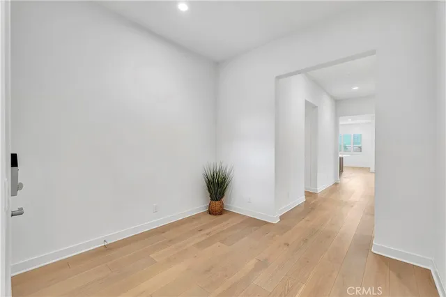 a view of a hallway with wooden floor and a glass door