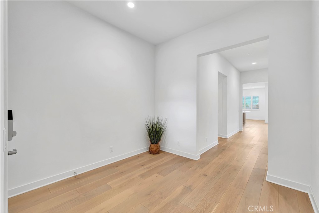 14432 Windfall Lane Huntington Beach, CA 92647 - Photo 5 of 62 a view of a hallway with wooden floor and a glass door
