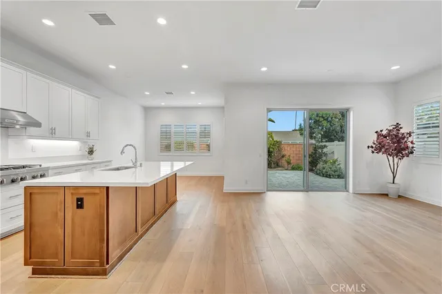 a kitchen with stainless steel appliances granite countertop a stove a sink and a refrigerator