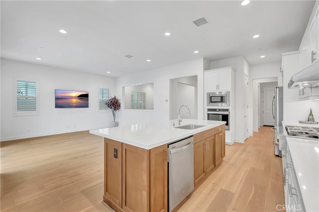 14432 Windfall Lane Huntington Beach, CA 92647 - Photo 10 of 62 a large kitchen with stainless steel appliances a sink and a refrigerator