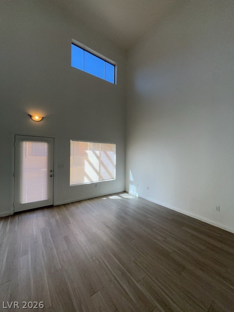 4915 East Russell Road, Unit 160 Las Vegas, NV 89120 - Photo 2 of 12 Unfurnished living room with dark wood-style flooring and a high ceiling