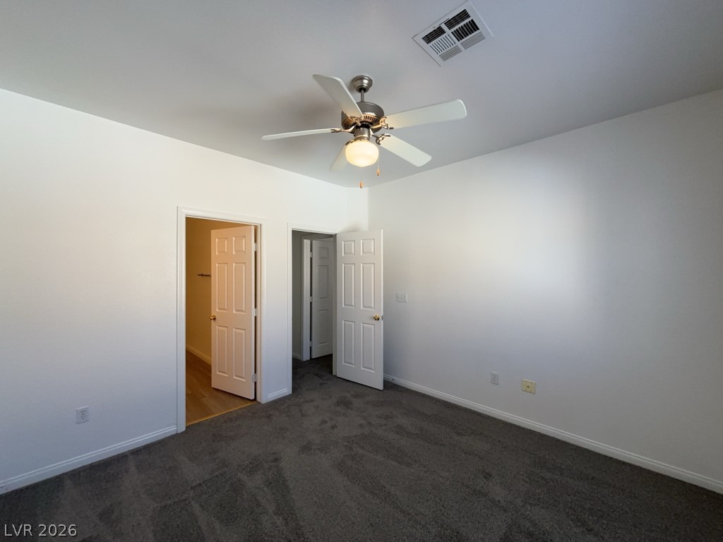 4915 East Russell Road, Unit 160 Las Vegas, NV 89120 - Photo 7 of 12 Unfurnished bedroom with dark carpet and a ceiling fan