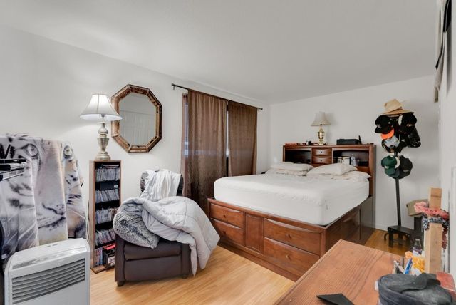 a living room with furniture a mirror and white walls