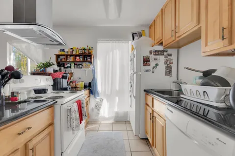 a kitchen with stainless steel appliances granite countertop a refrigerator and a stove