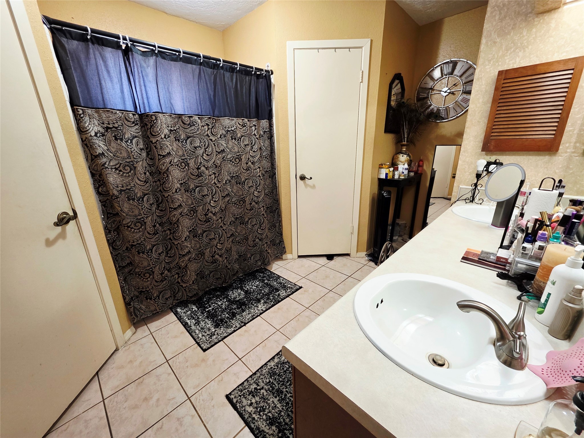 1323 Padstow Lane Channelview, TX 77530 - Photo 10 of 11 This bathroom features a tiled floor, a double sink vanity with ample counter space, and additional storage options.