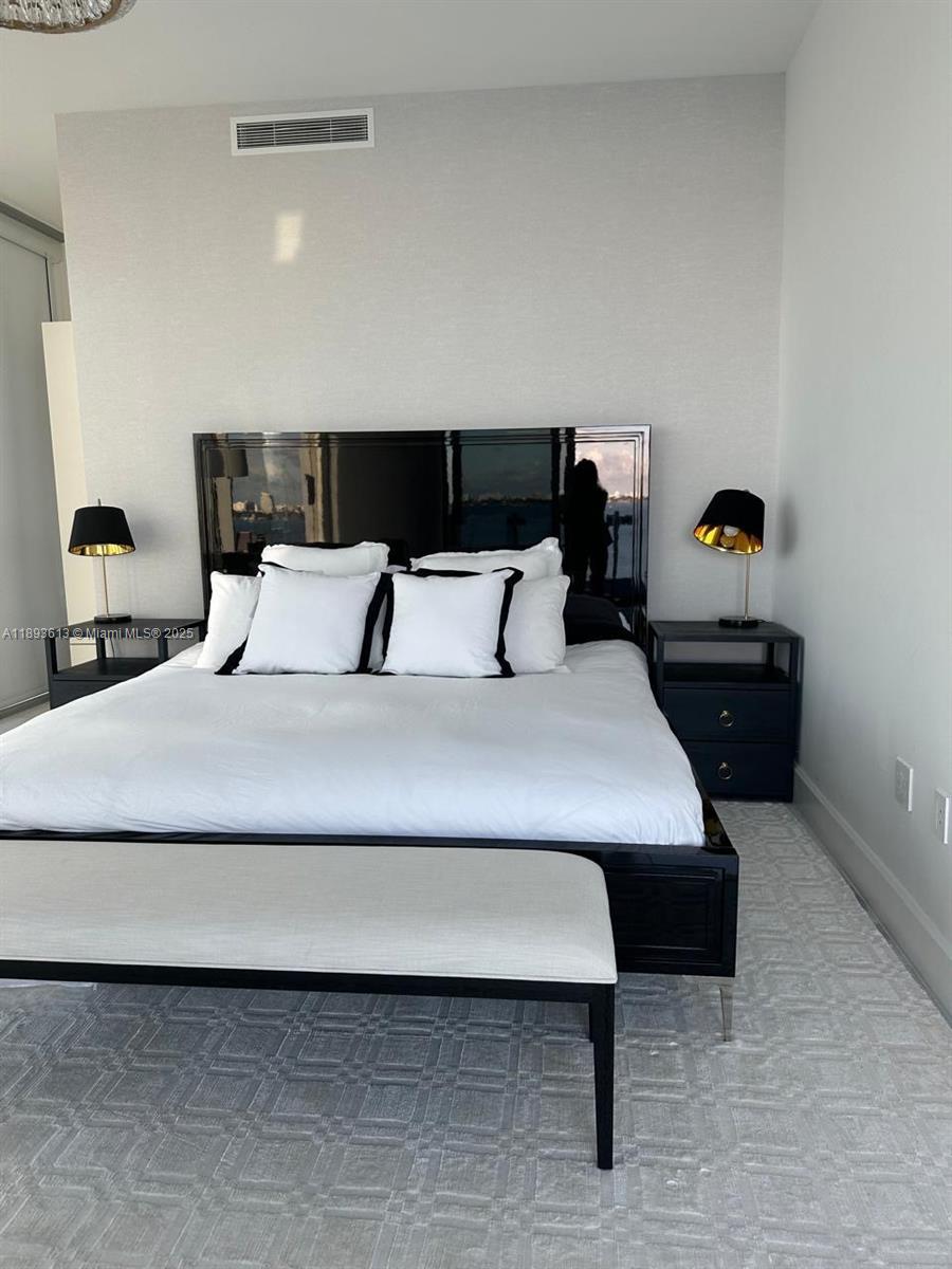 700 Northeast 26th Terrace, Unit 803 Miami, FL 33137 - Photo 7 of 13 a bedroom with a bed and lamp